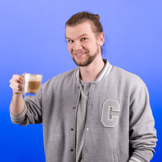 Geschäftsführer Chris mit einer Tasse Kaffee